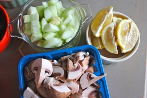 Chopped cucumber, mushrooms, and lemon wedges.